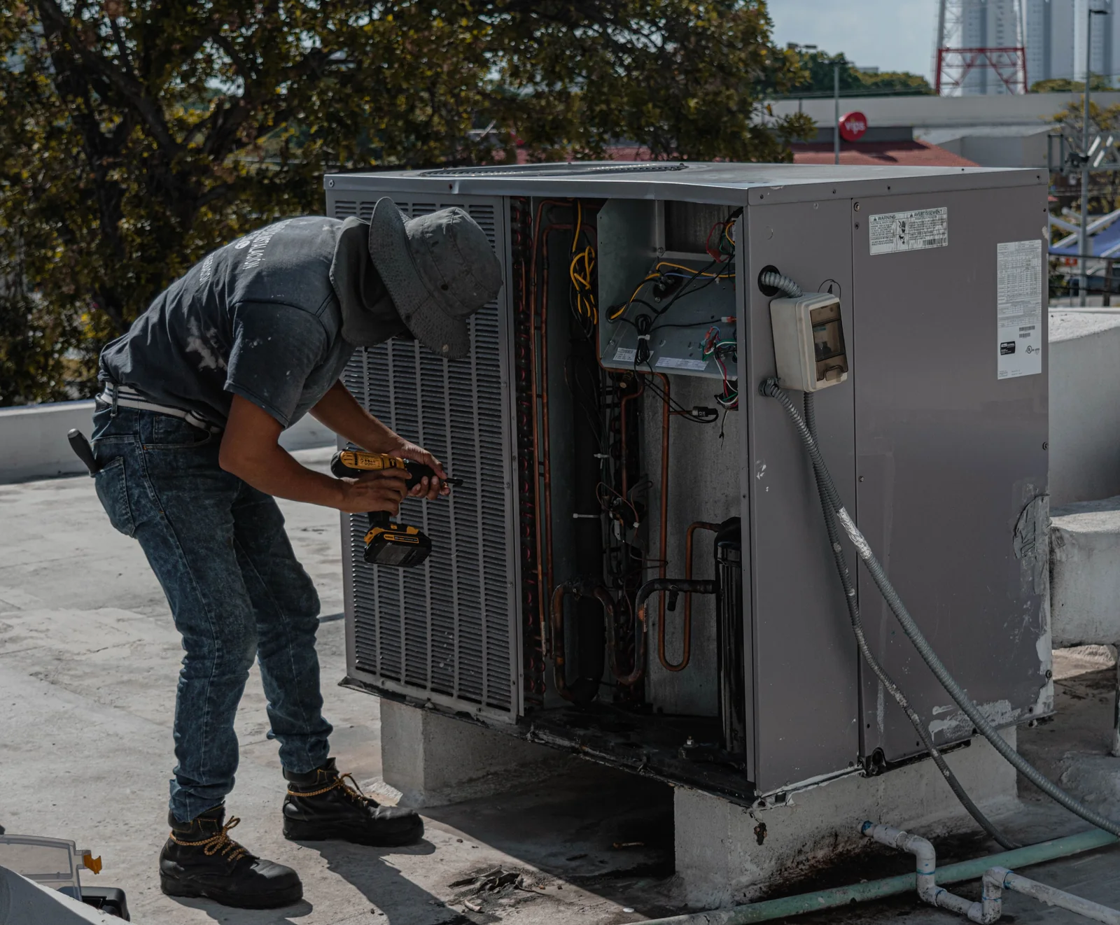 HVAC technician servicing a rooftop AC unit